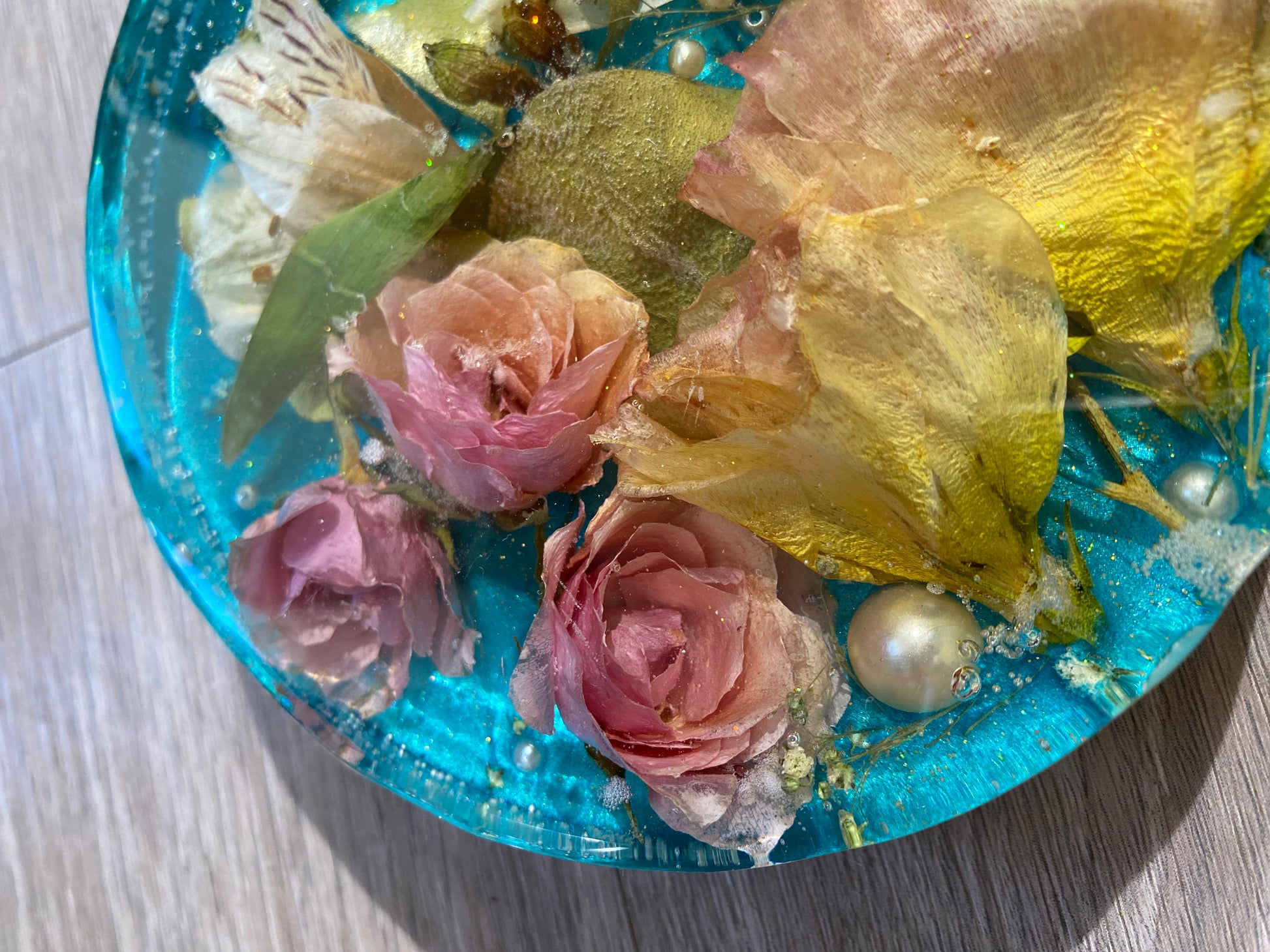 Pink mini roses preserved in 6 in resin tray decorated lightly with glitter for enhancement and plastic pearls 