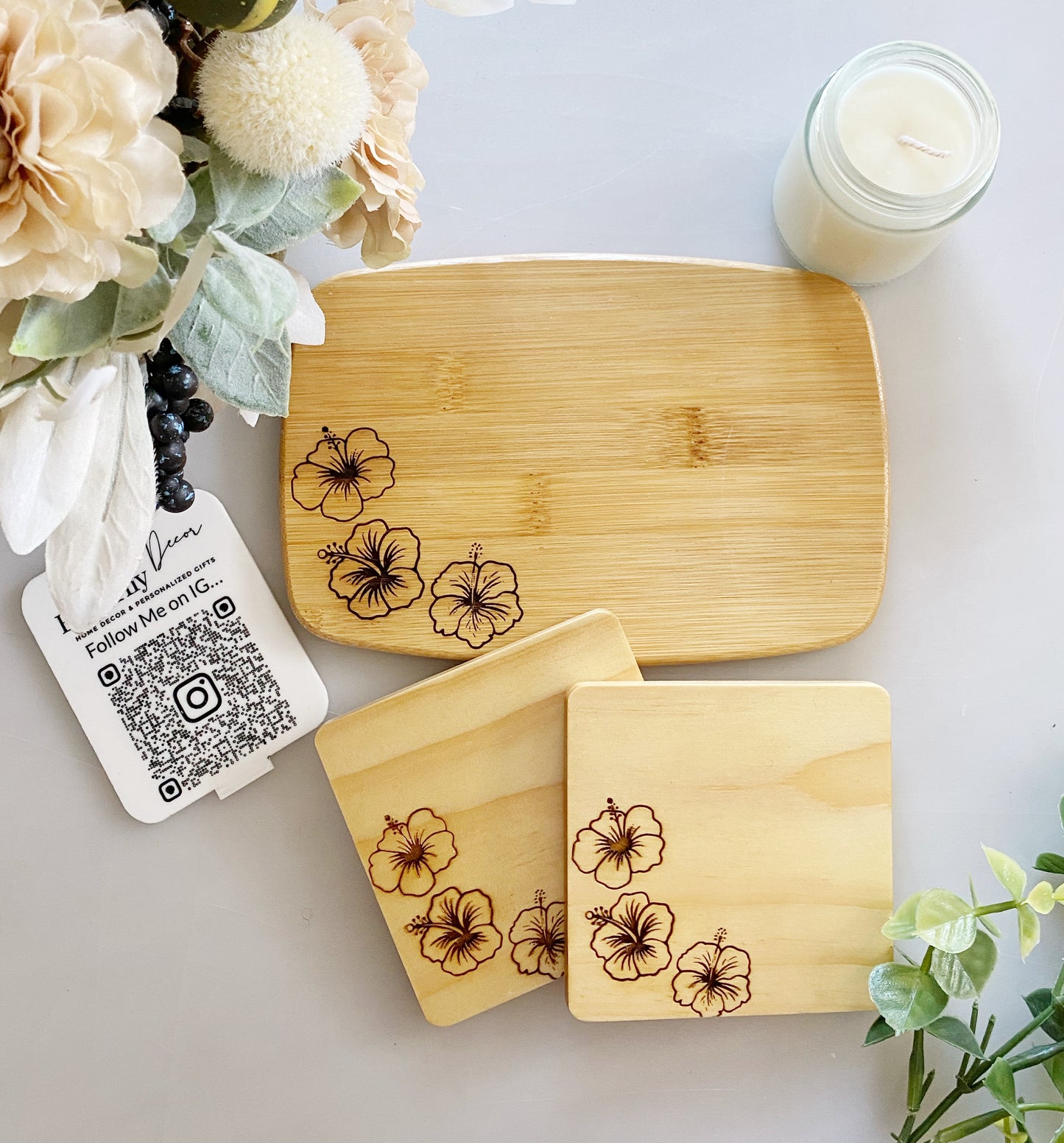 Bamboo cutting and serving board with three hibiscus flowers engraved on the bottom left. Great for use as a candle, jewelry or trinket tray. Can add names and dates for personalization. Also available to create a bundle 4 inch wood coasters with matching engraving All wood is sealed with butcher block clear stain for protection 